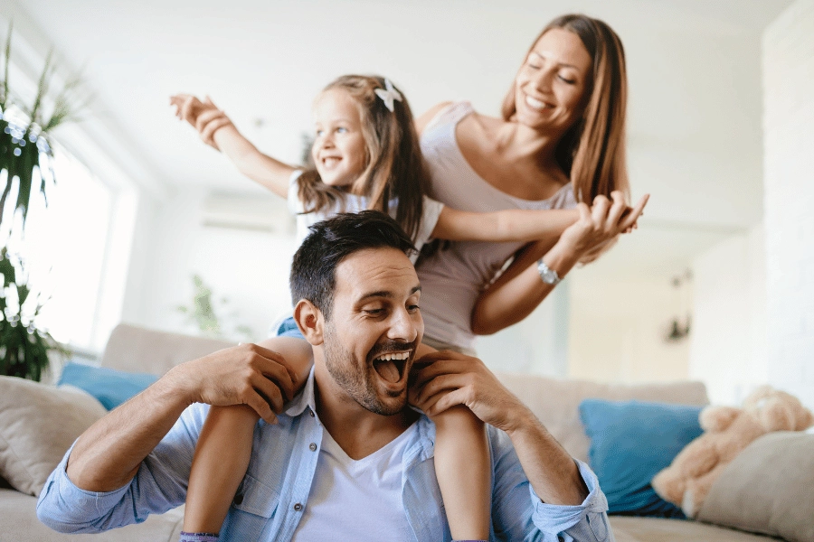 mom, dad, and their daughter happy and having fun at home